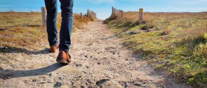 les jambes de quelqu'un qui marche sur la plage